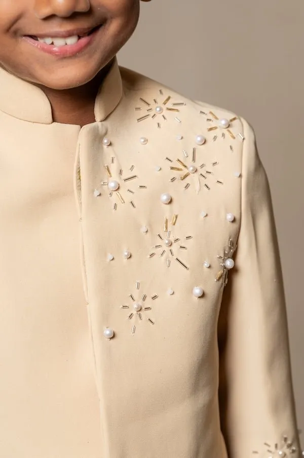 Elegant light beige bandhgala suit with delicate floral embroidery, paired with matching slim-fit trousers for a refined and sophisticated look